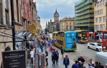 Welcome sign to Gladstone's Land and bustle on the Royal Mile