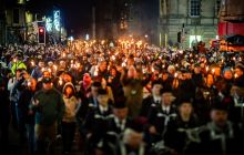 Pipe band and torchbearers on Royal Mile at Hogmanay Torchlight Procession