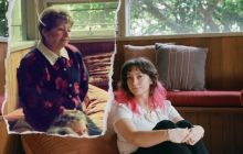Beth Peterson on the floor on the right, sitting, with her grandmother on a pench, looking at her.