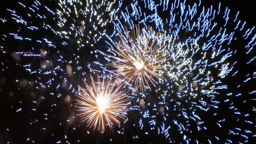 Fireworks - 2 blue yellows bursts against dying big blue burst