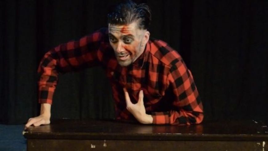 Simon Shaw as Ed Gein gestures with blood on his face