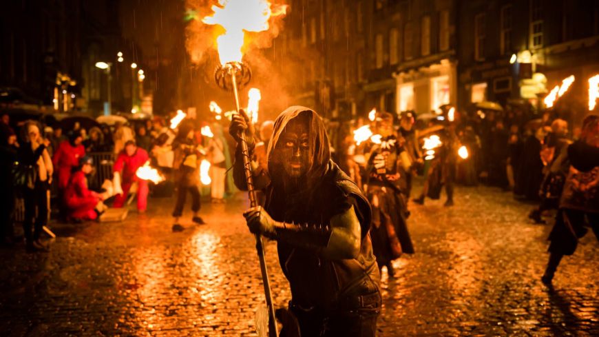 Photo of person standing holding a firey torch 