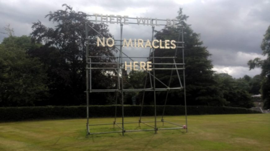 Modern 2 Gallery installation in garden saying "There Will be No Miracles Here"