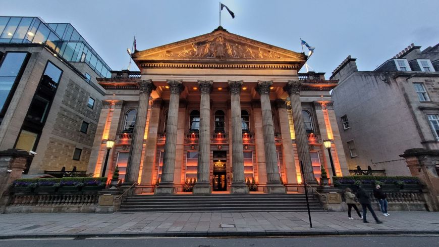 The six columns of the neo-classical Dome bar on Edinburgh's George Street are lit up in dramatic, soft orange and yellow lighting