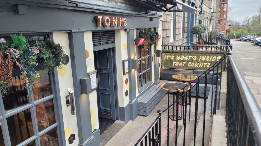 The front of Tonic, a cocktail bar in a Georgian basement building, with a sign saying "It's what's inside that counts"