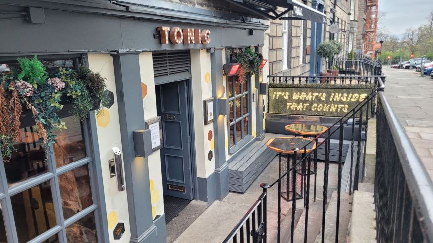 The front of Tonic, a cocktail bar in a Georgian basement building, with a sign saying "It's what's inside that counts" 