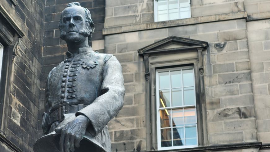 Statue of James Braidwood from waist upward holding his helmet in hand