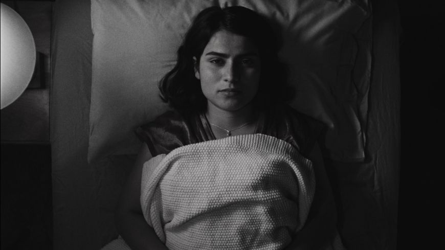 Black and white still image of Anaita Wali Zada lying looking up in the movie Freemont (2023)  