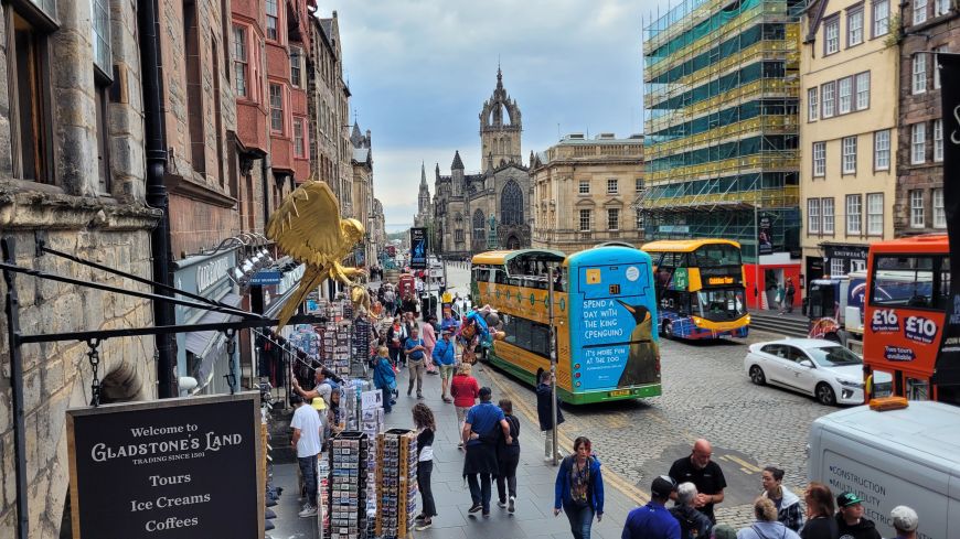 Welcome sign to Gladstone's Land and bustle on the Royal Mile