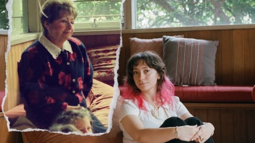 Beth Peterson on the floor on the right, sitting, with her grandmother on a pench, looking at her.