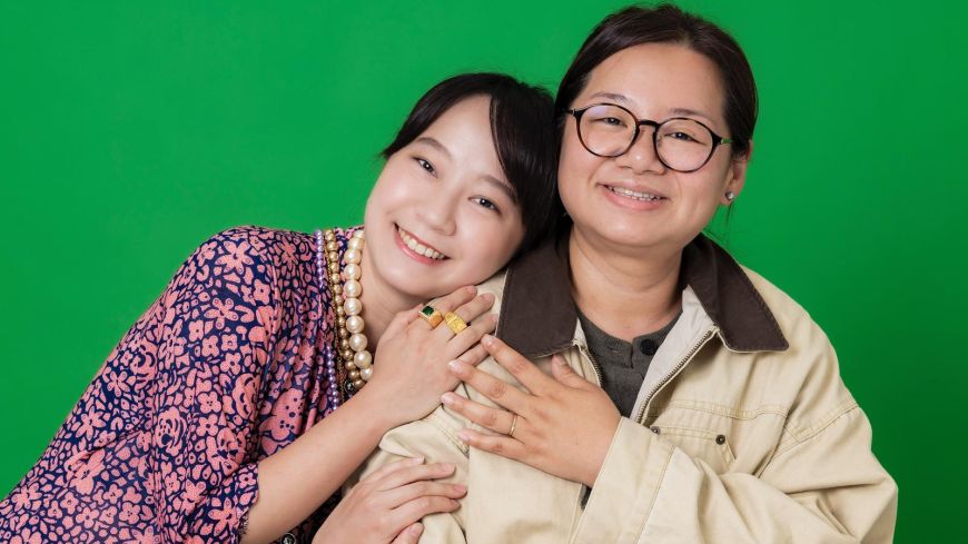 Cathy Lam and Kasen Tsui are pictured hugging, smiling for the camera.