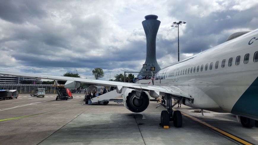 Passengers board a plaine at Edinburgh Airport with the control tower in the background