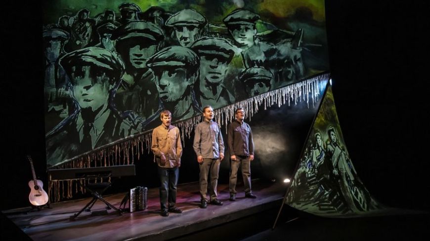 L-R: David Eagle, Sean Cooney and Michael Hughes stand in front of the backdrop of an animation of Hunger Marchers.