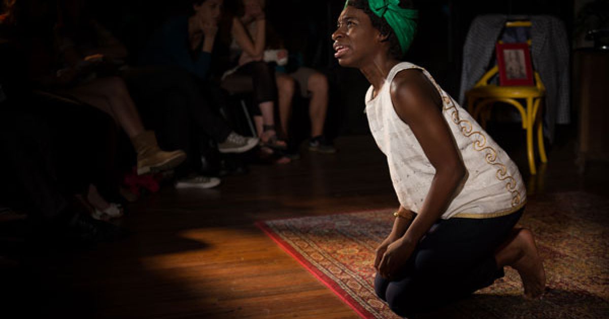 Apphia Campbell, as Mina Bordeaux, kneels in lament.