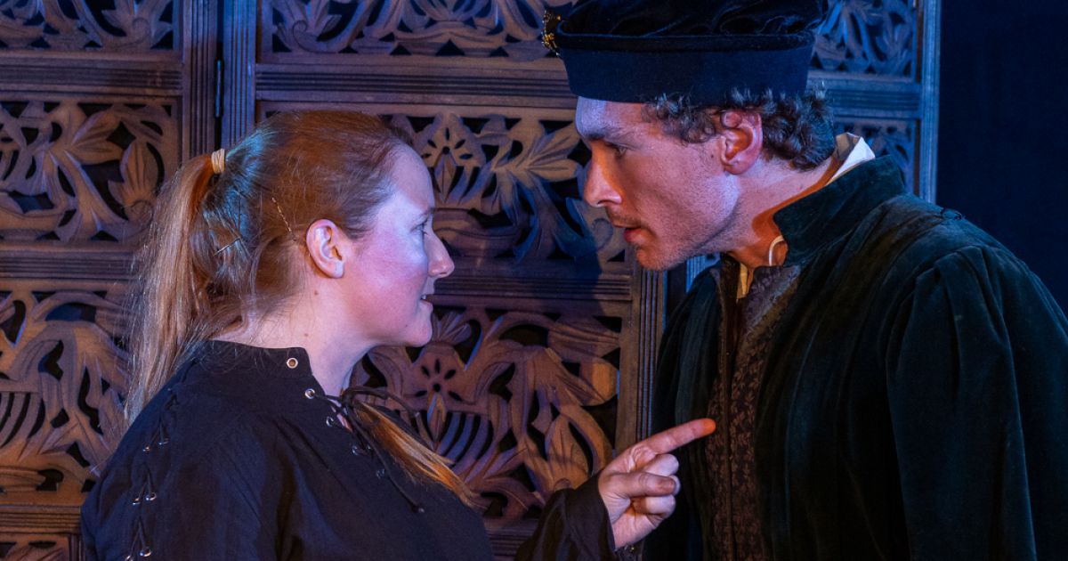Lexi Wolfe (left) and Adam Phelan (right) facing each other in a heated argument.