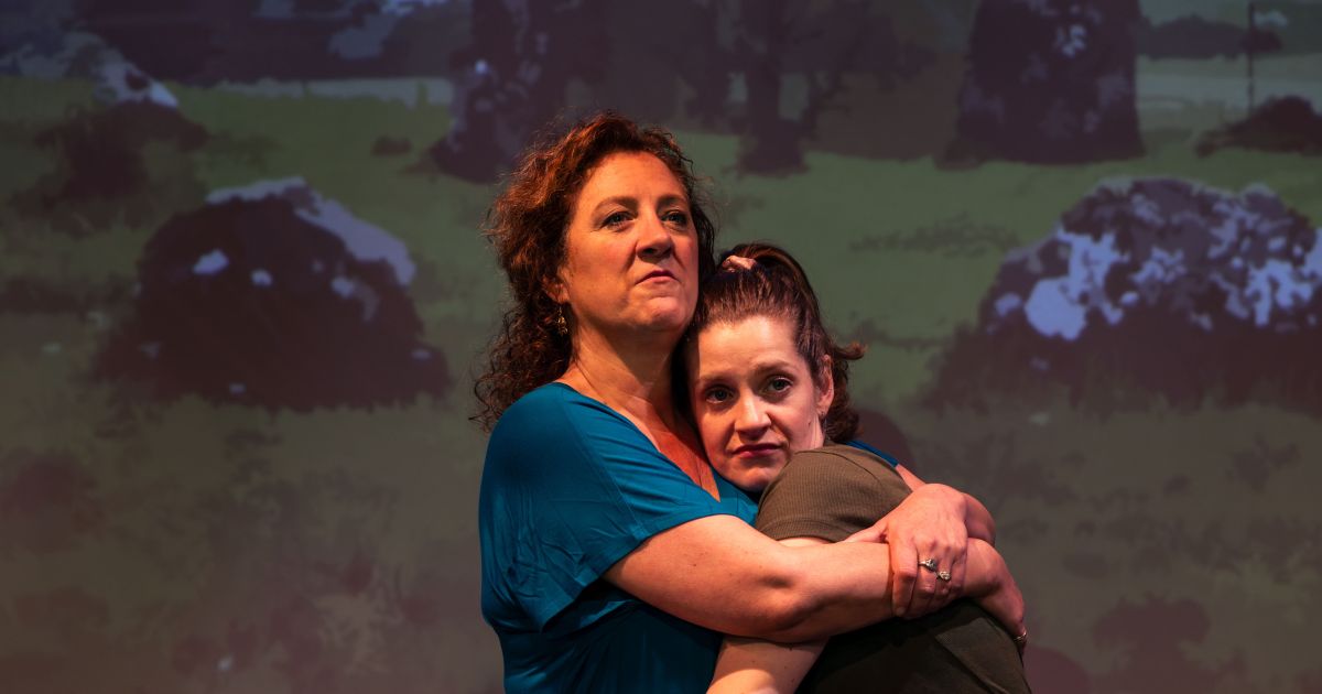Two of the actors hug on stage - Annie Lareau, Brenda Joyner
